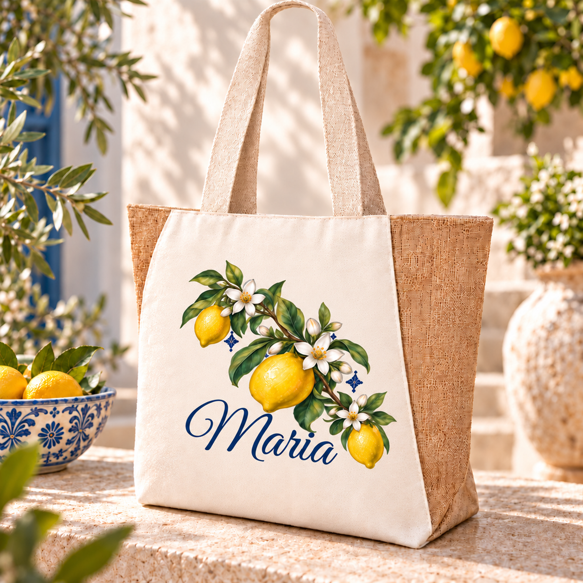 Naturfarbener Shopper mit geschwungenem Zweig, drei Zitronen und blauem Wunschnamen in mediterraner Umgebung.
