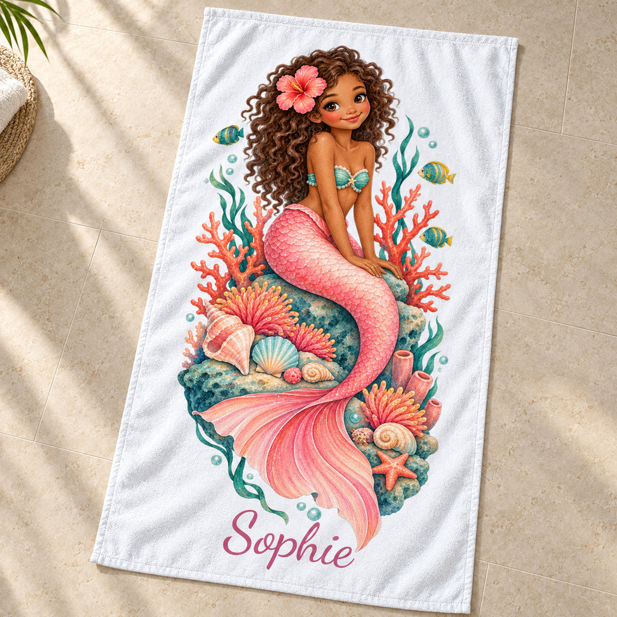Handtuch mit Motiv Korallengarten und Beispielname Sophie, schräg von oben gezeigt.
