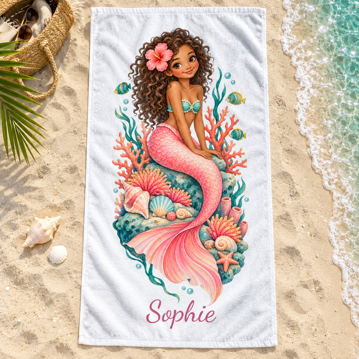 Handtuch mit Meerjungfrauenmotiv Korallengarten und Beispielname Sophie auf Sand am Strand.