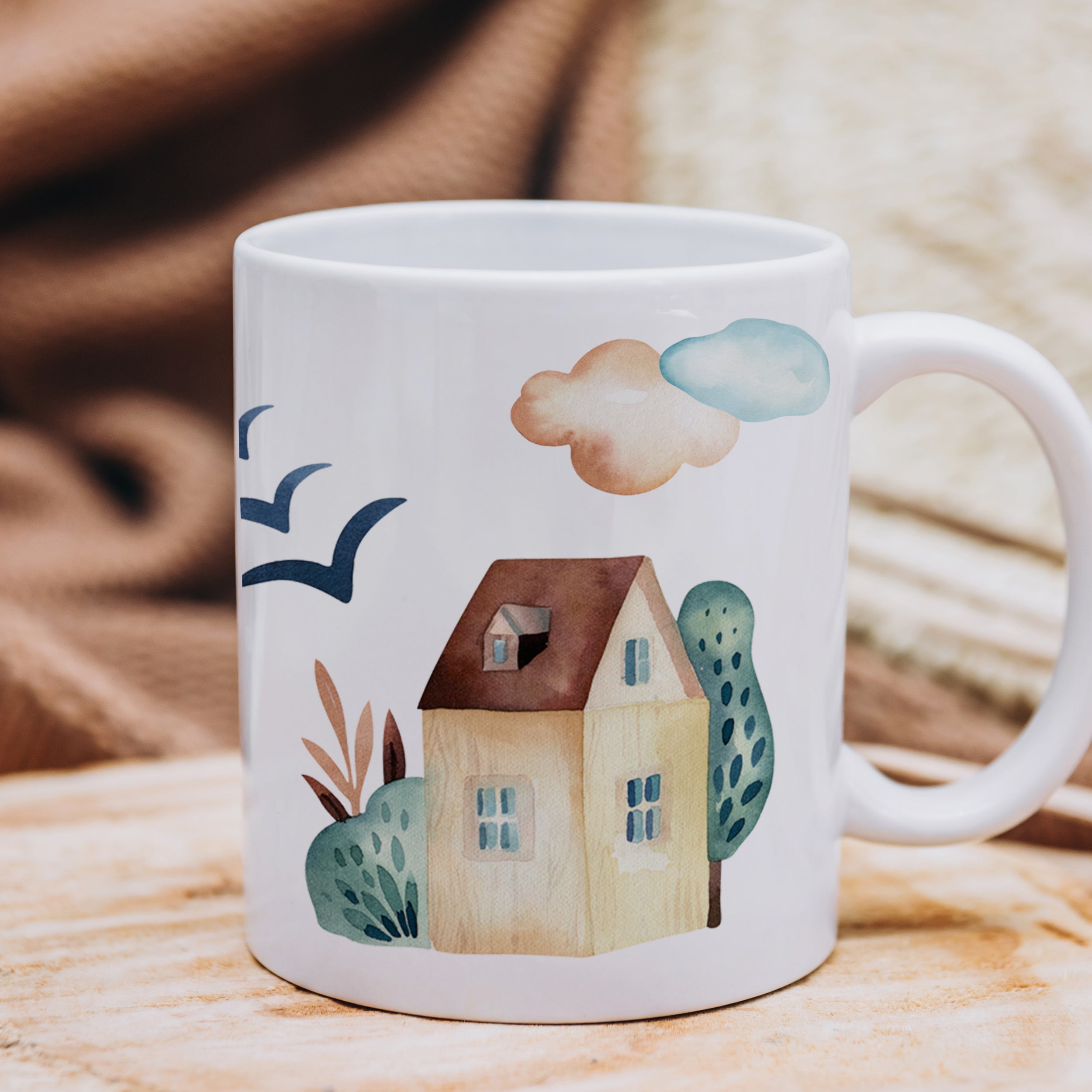 Weißer Becher mit Haus, Wolken und Pflanzenmotiven.