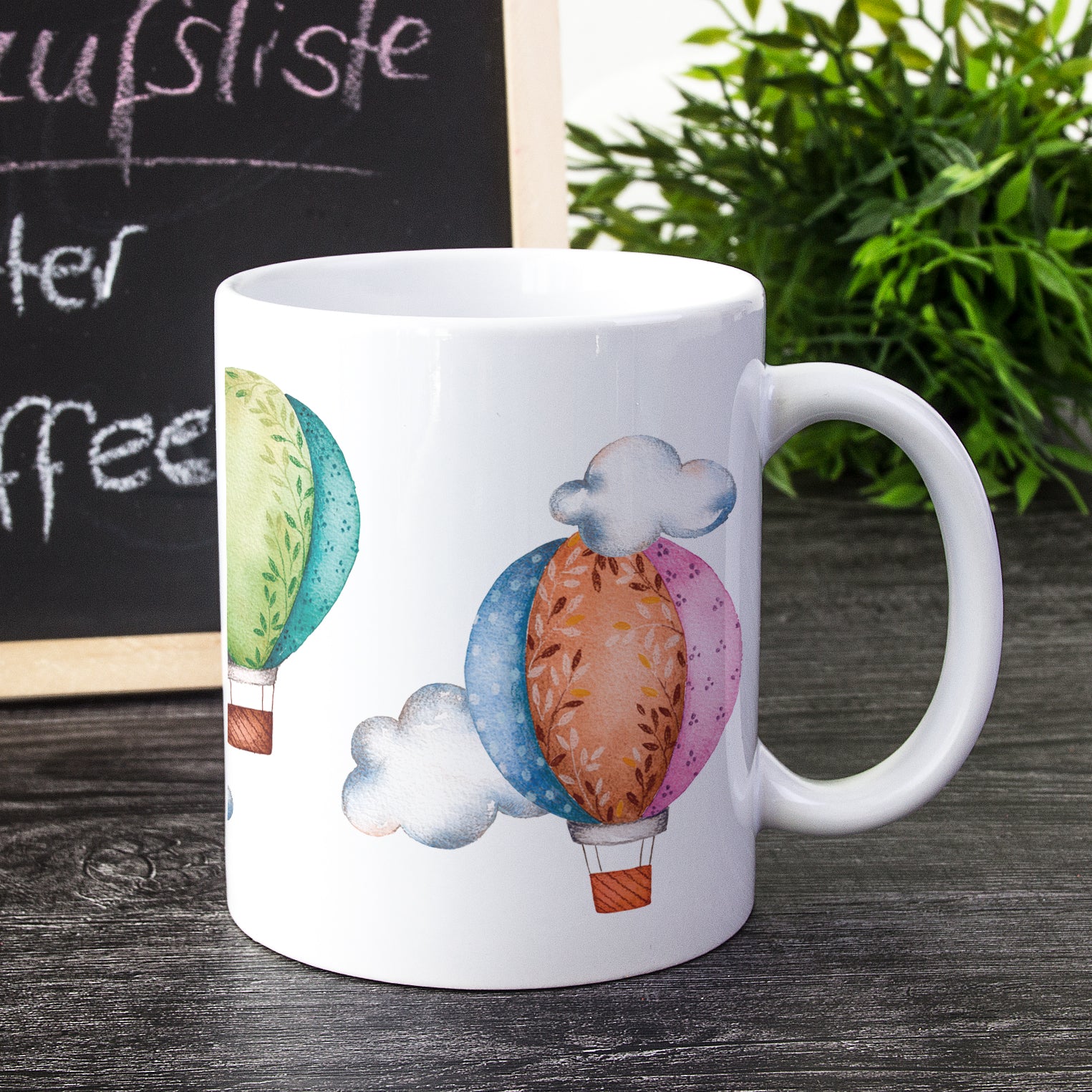 Tasse mit bunten Heißluftballons und Wolkenmotiven.