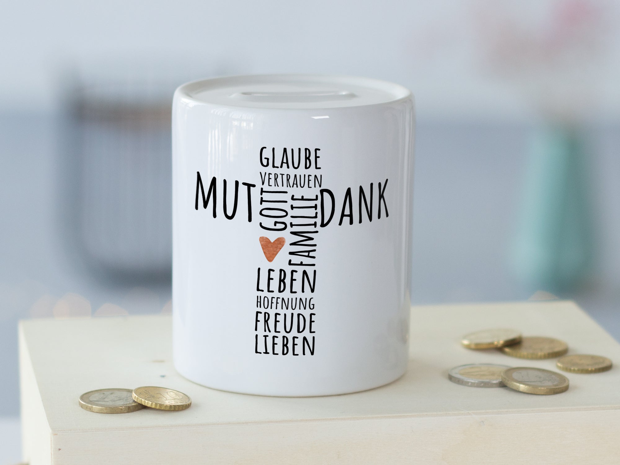 Weißes Sparschwein mit Motiv "Mut, Dank, Liebe" in Schwarz.