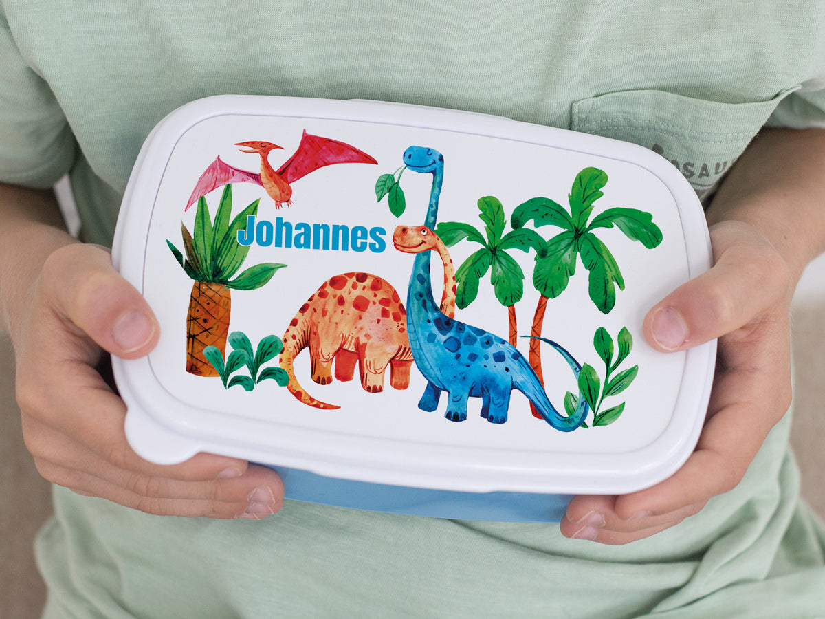Bunte Brotdose mit Dinosauriern und personalisiertem Namen.