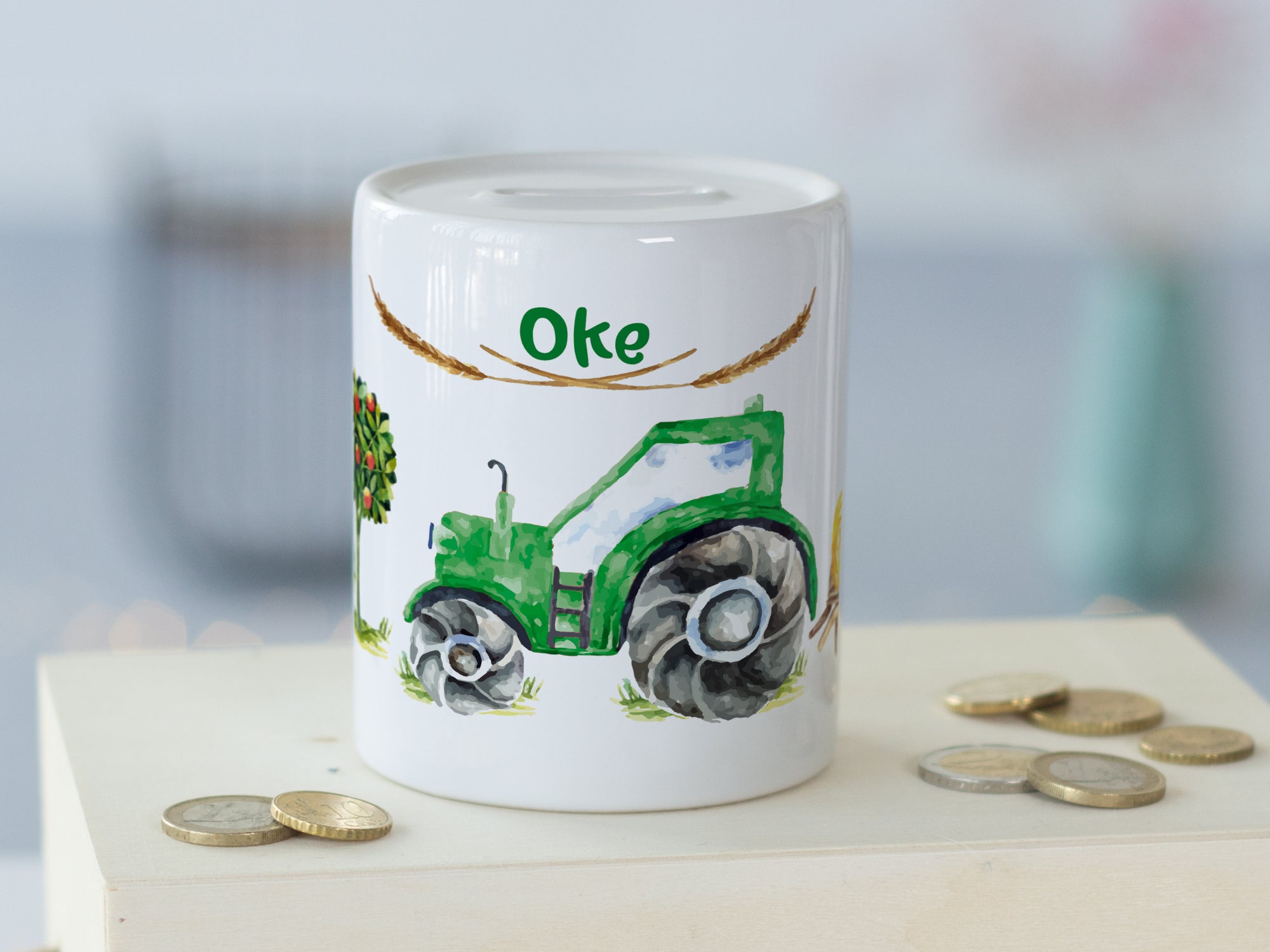 Grüne Sparbüchse mit Traktor-Motiv und Schriftzug "Oke".