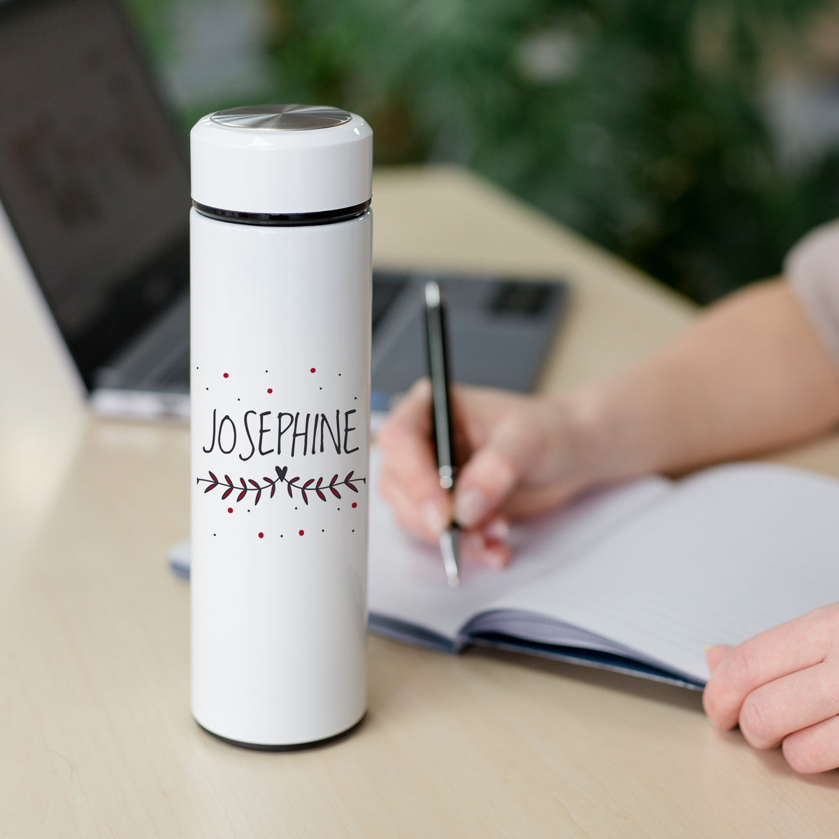 Weiße Thermosflasche mit dem Namen "Josephine" und dekorativen Zweigen.