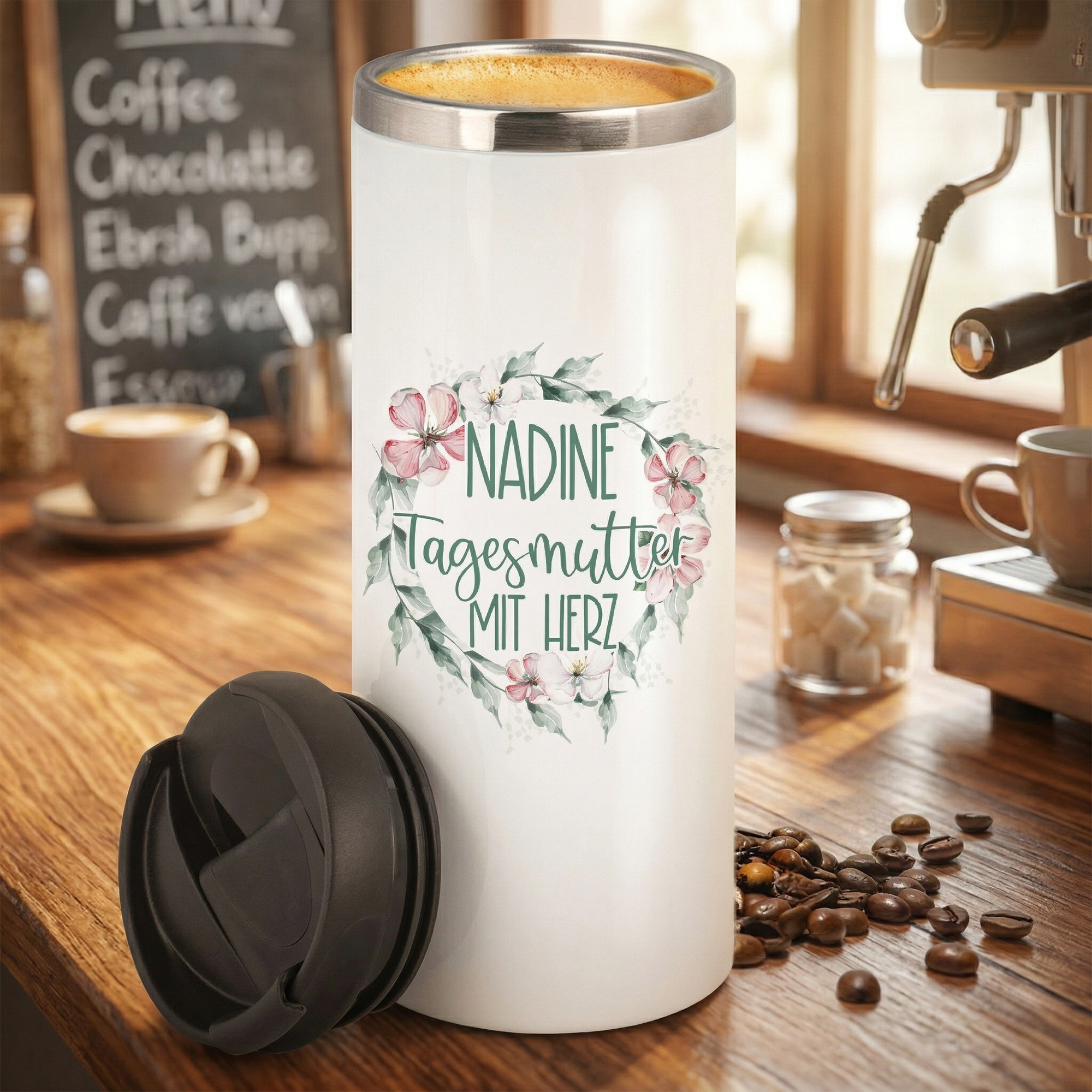 Weißer Thermobecher mit floralem Design und personalisiertem Text.