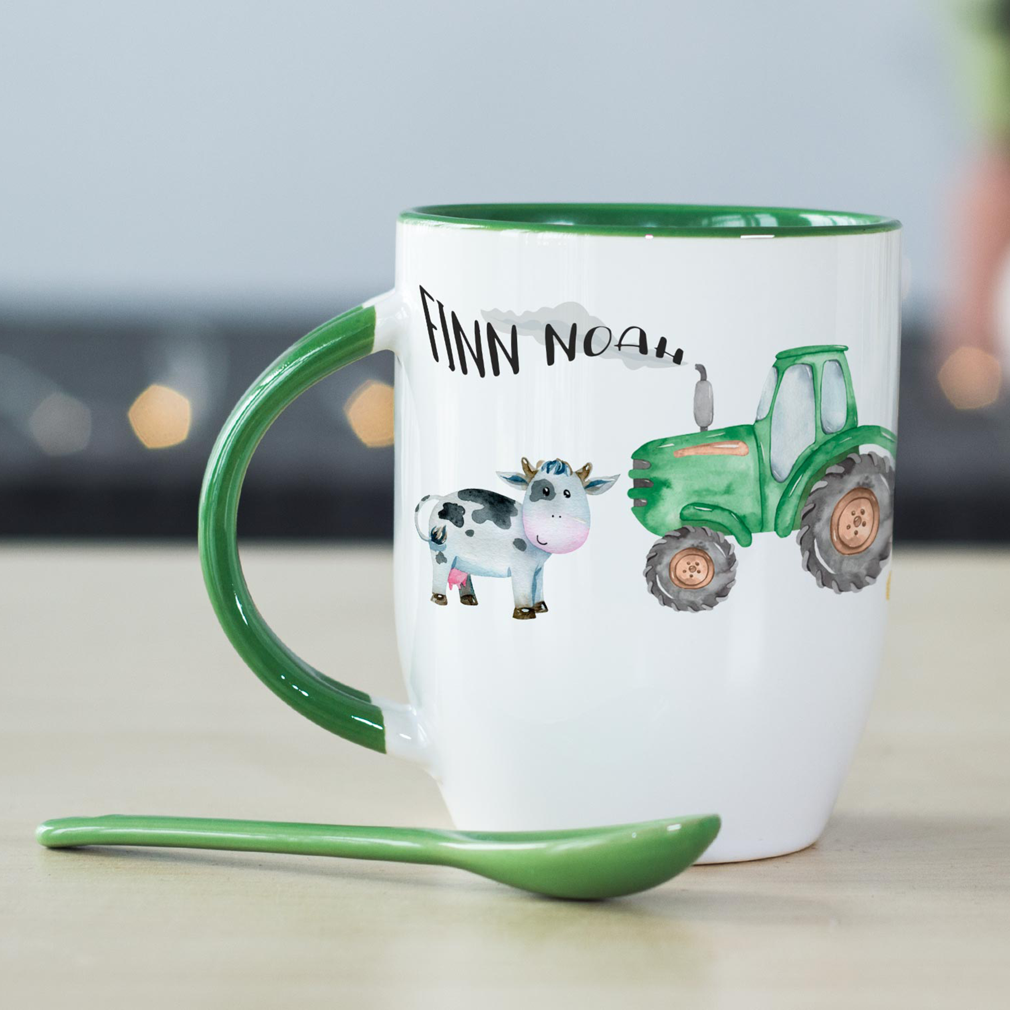 Tasse mit grünem Henkel, Kuh und Traktor-Design.