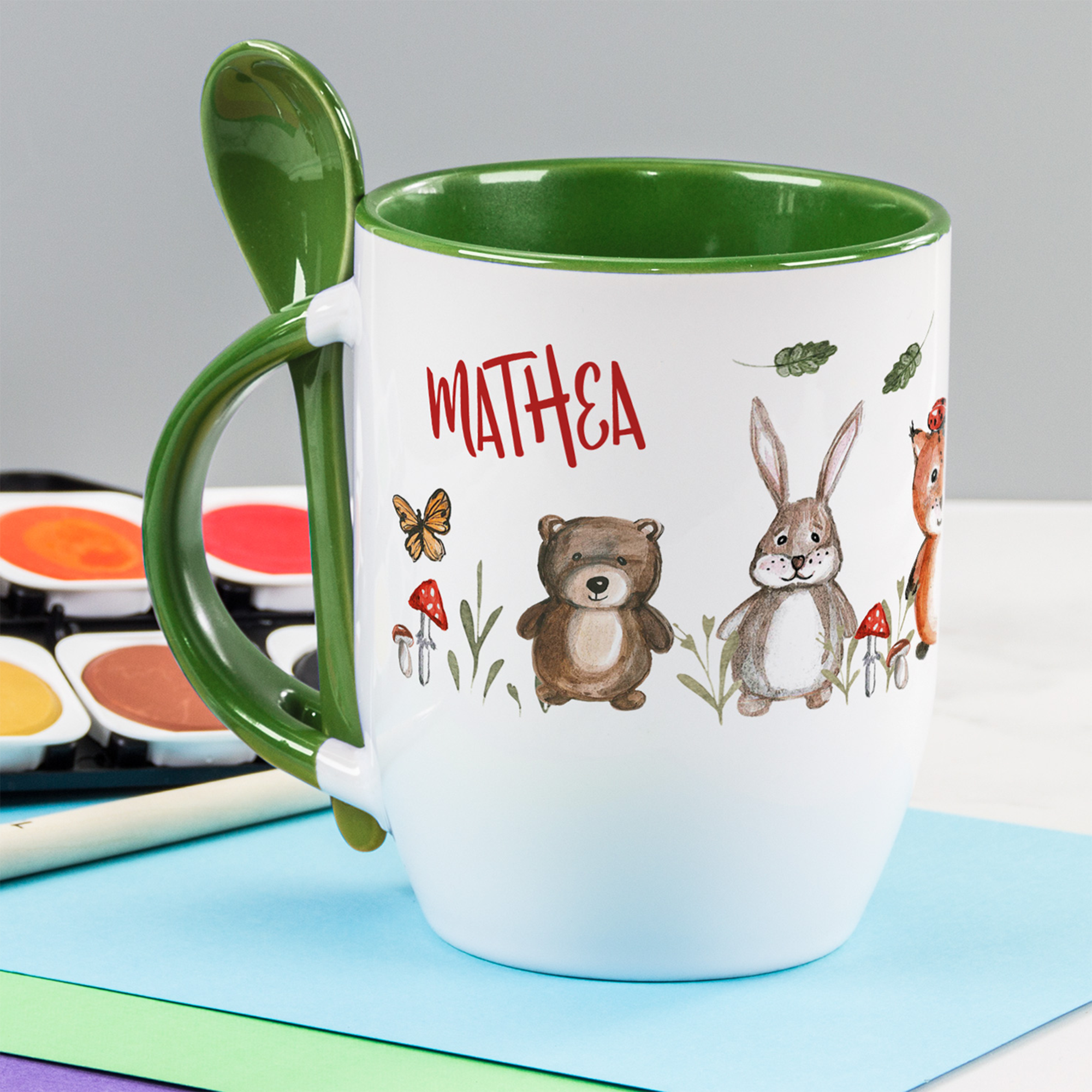 Becher mit grünem Henkel und Tiermotiven, personalisiert mit "MATHEA".