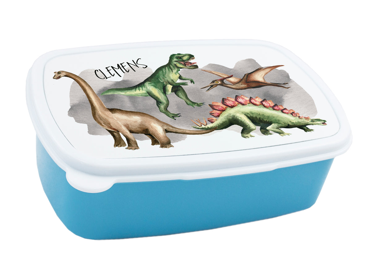 Blaue Brotdose mit Dinosaurier-Motiven und Namen "Clemens".