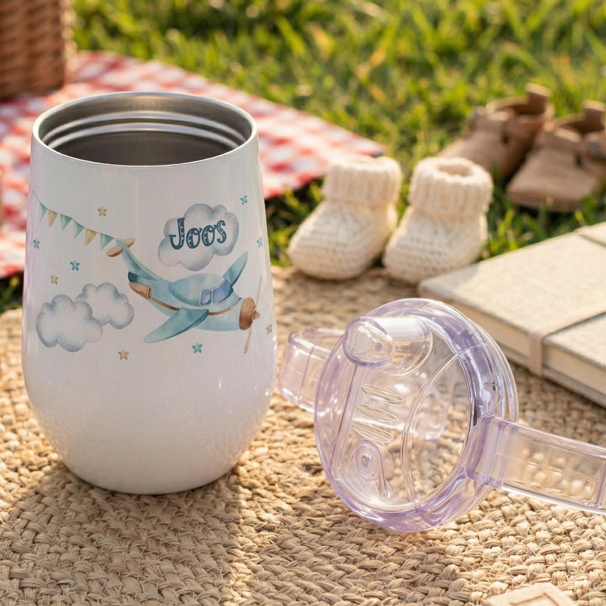 Weißer Becher mit buntem Vogelmotiv und lila Deckel.