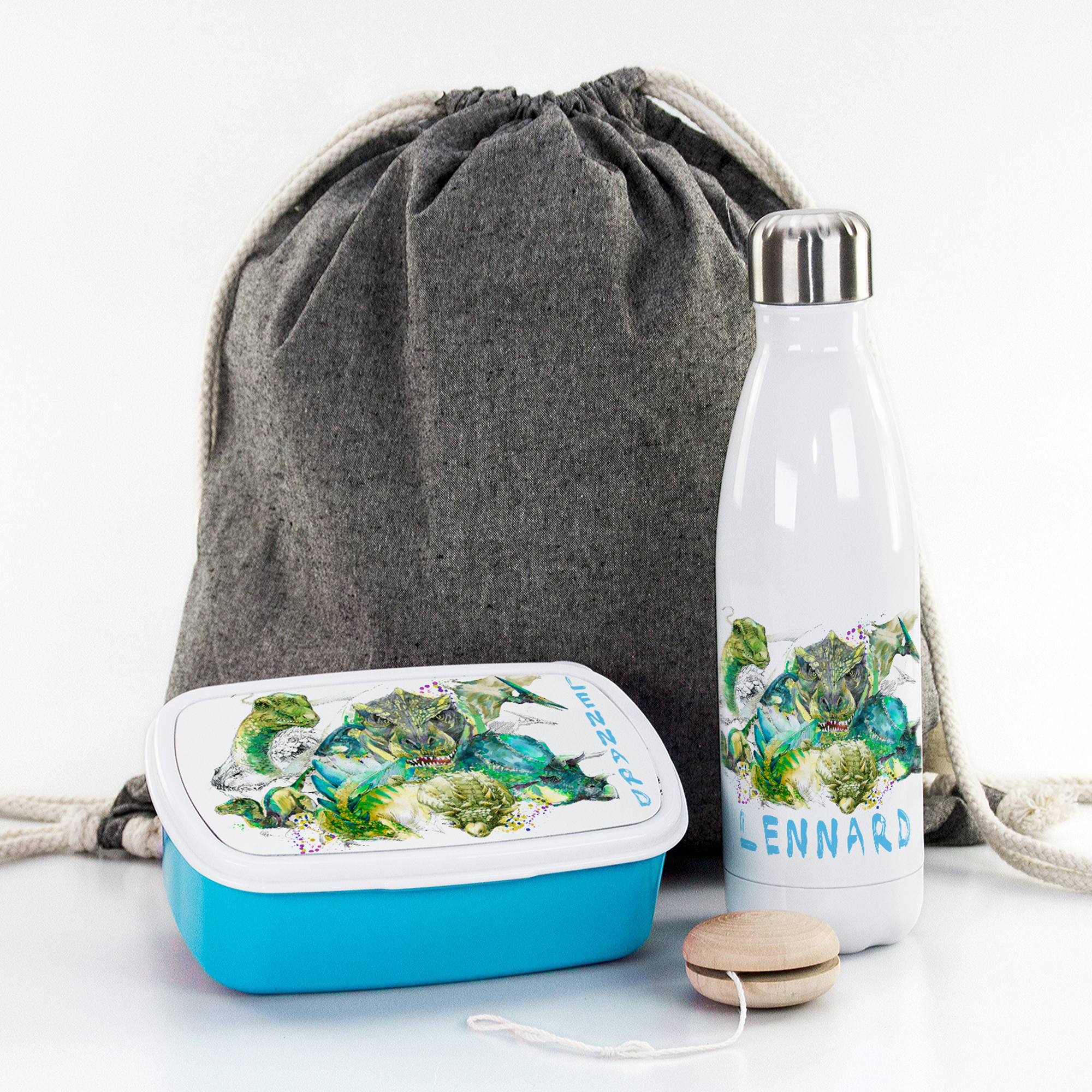 Graue Tasche, blaue Brotdose, weiße Trinkflasche mit Pflanzenmotiv.