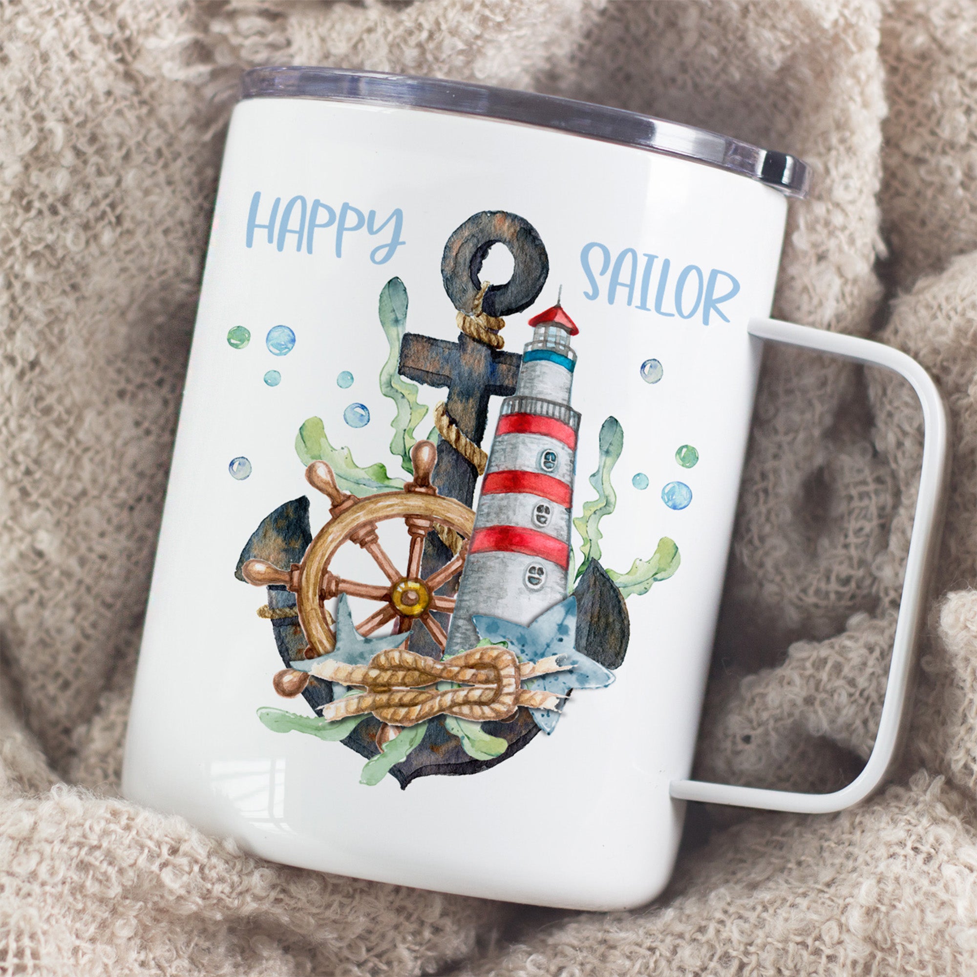 Tasse mit Anker, Steuerrad und Leuchtturm, bunt.