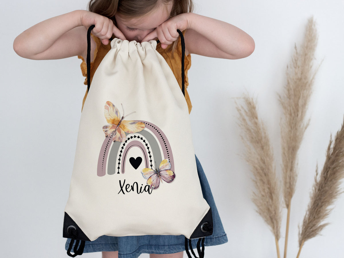 Beiger Rucksack mit Regenbogen und Schmetterlingen, Name Xenia.