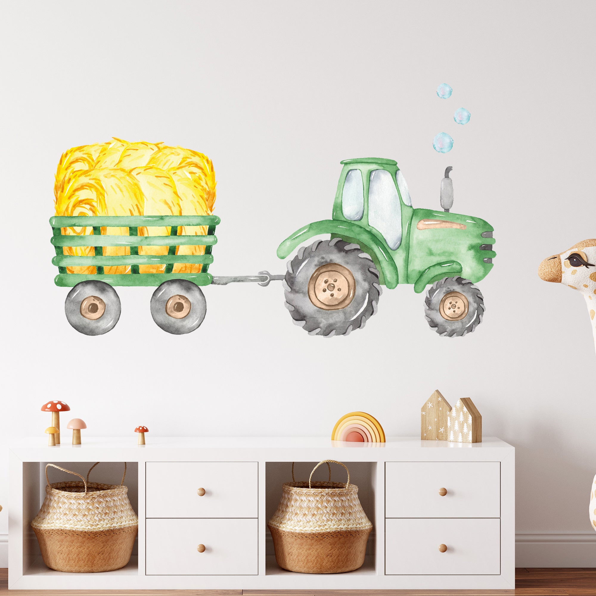Grüner Traktor mit Heuballen auf einem Anhänger.