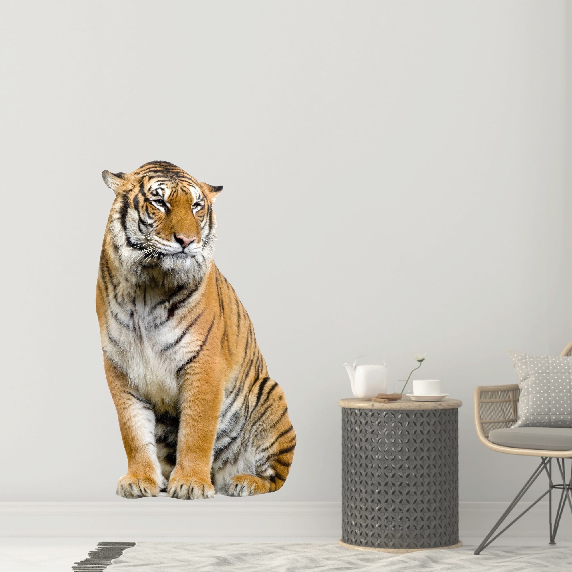 Sitzender Tiger in orange und schwarz vor neutralem Hintergrund.
