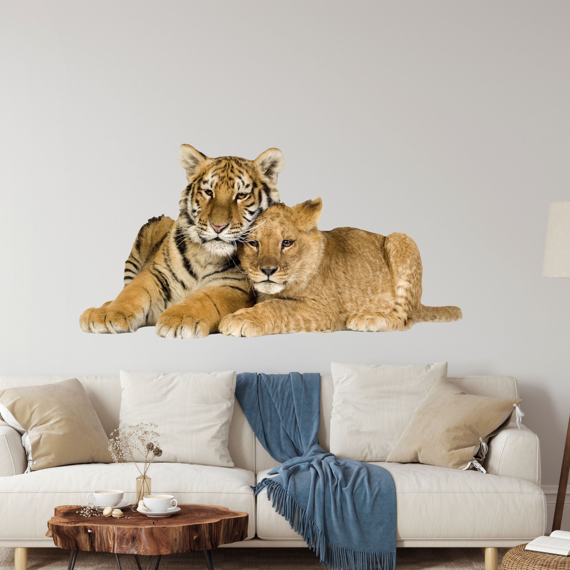 Tiger und Löwe liegen entspannt auf einer Couch.