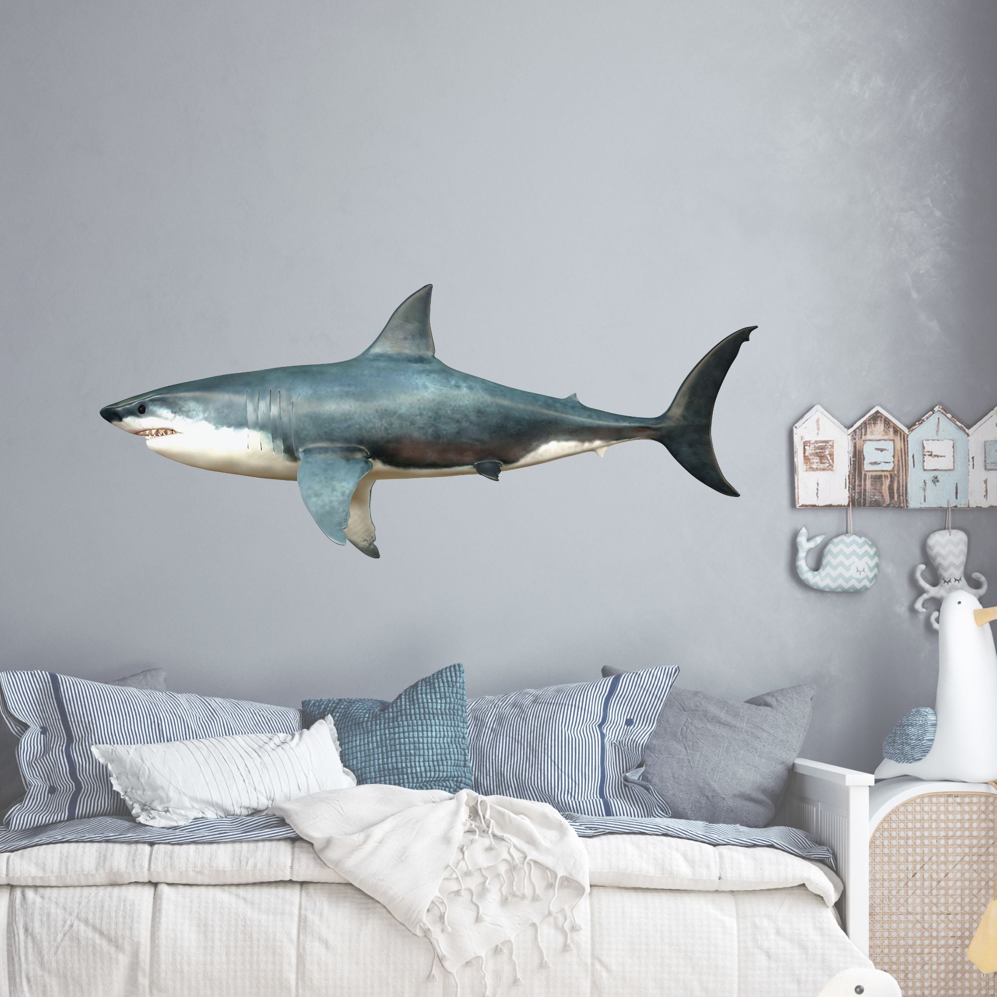 Grauer Wandhai über einem gemütlichen Bett mit Kissen.