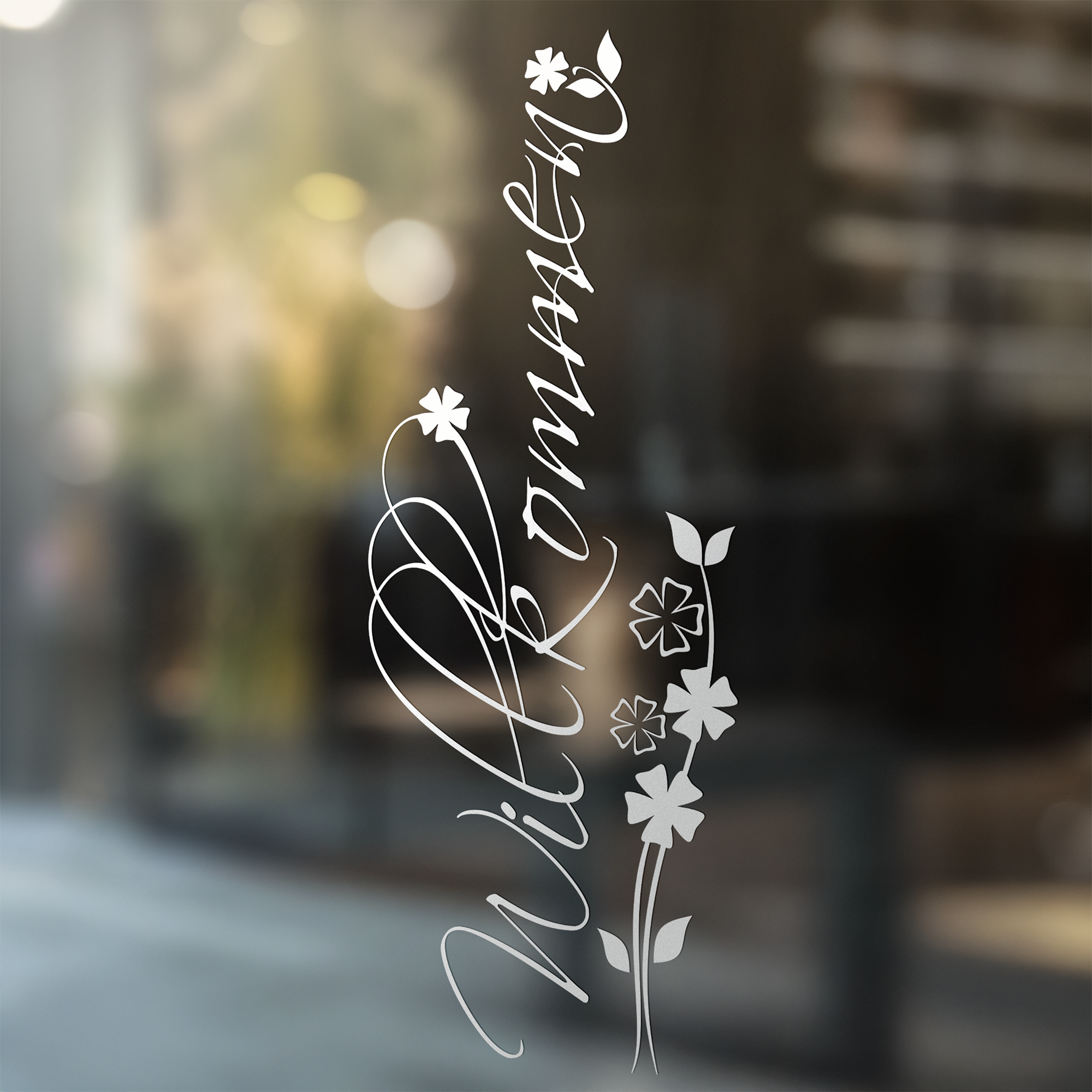 Willkommen Schriftzug in Weiß mit floralen Motiven.