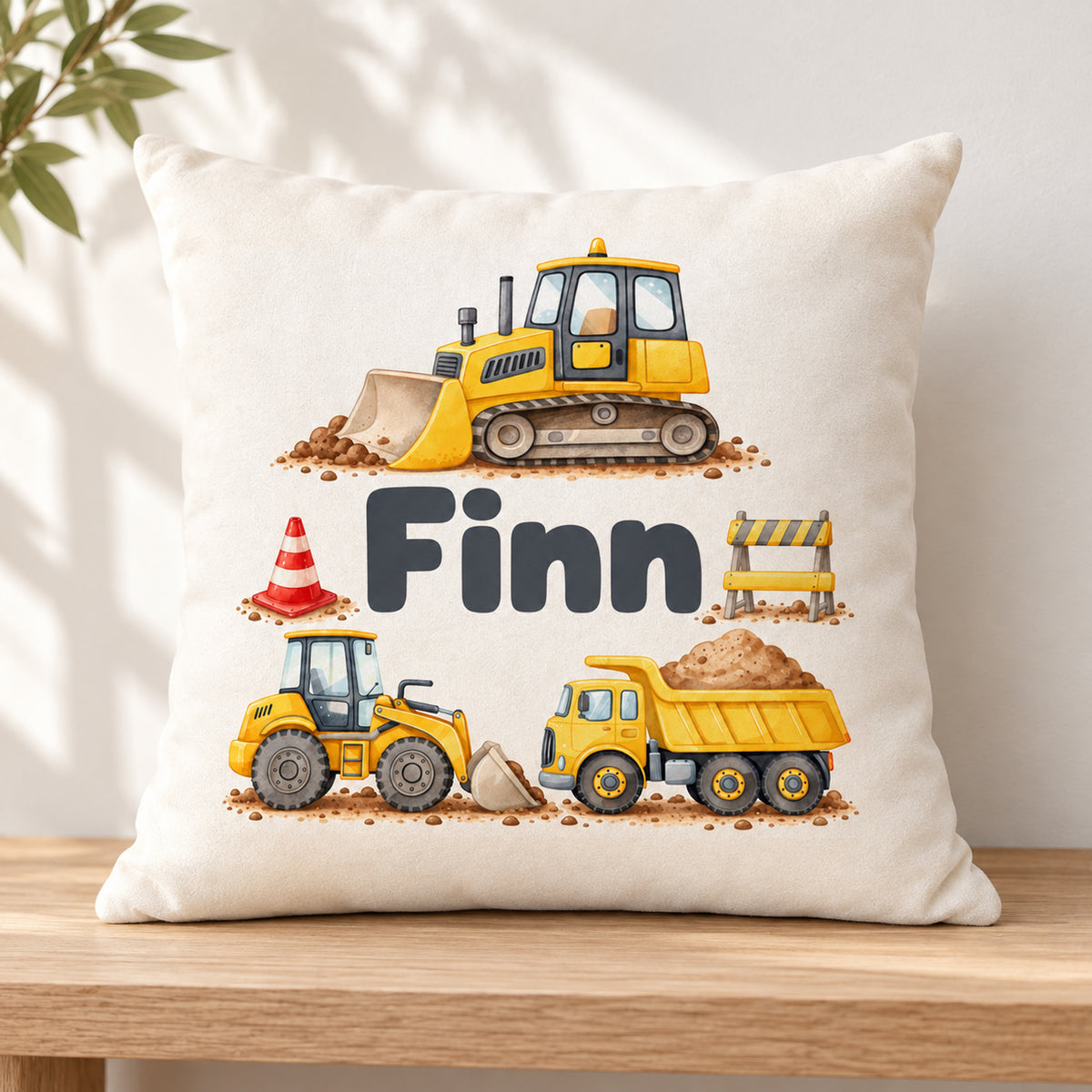 Kissenbezug mit Planierraupe, Radlader und Kipplaster und Beispielname Finn in einer schlichten Leseecke.
