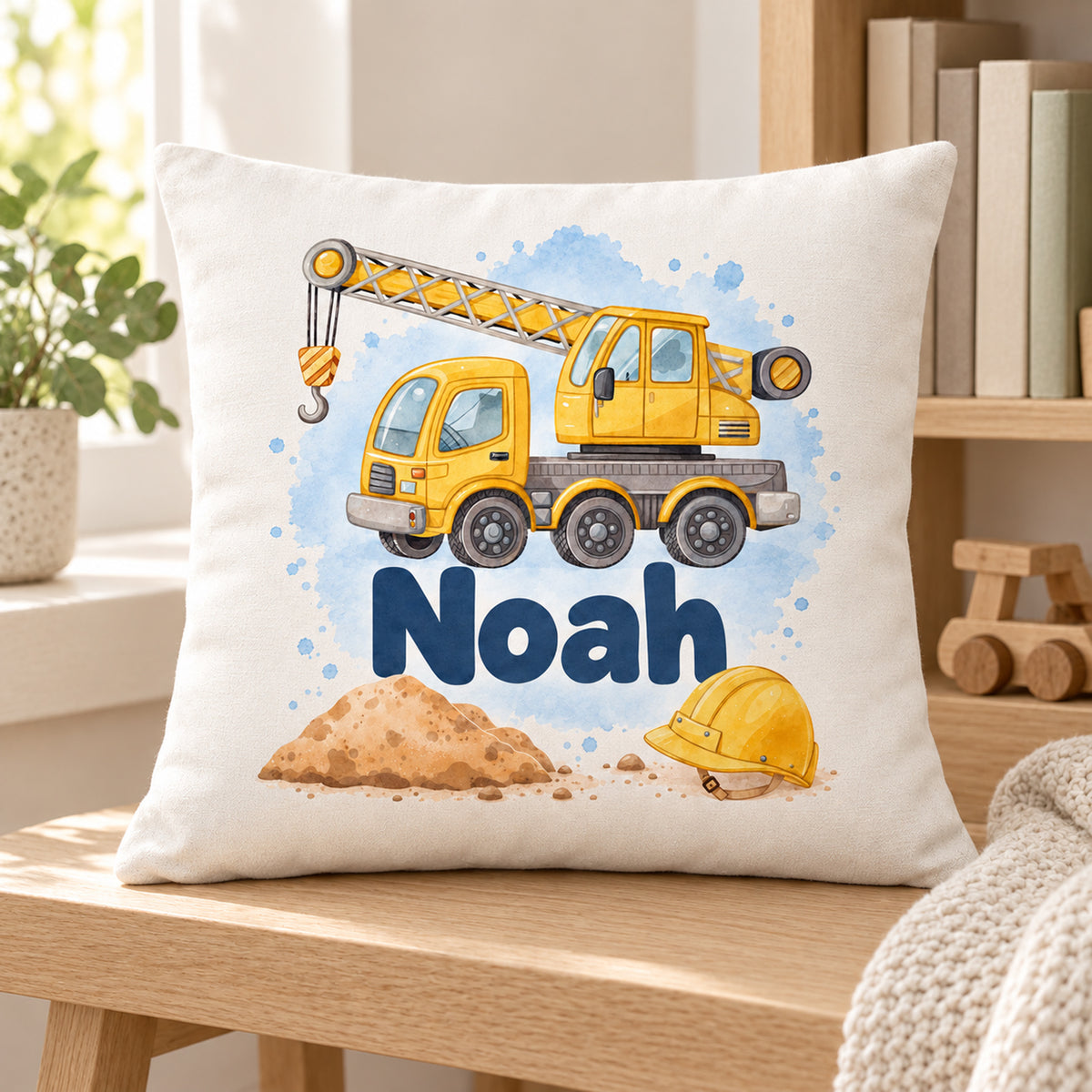 Kissenbezug mit Kran und Beispielname Noah in einer schlichten Leseecke.