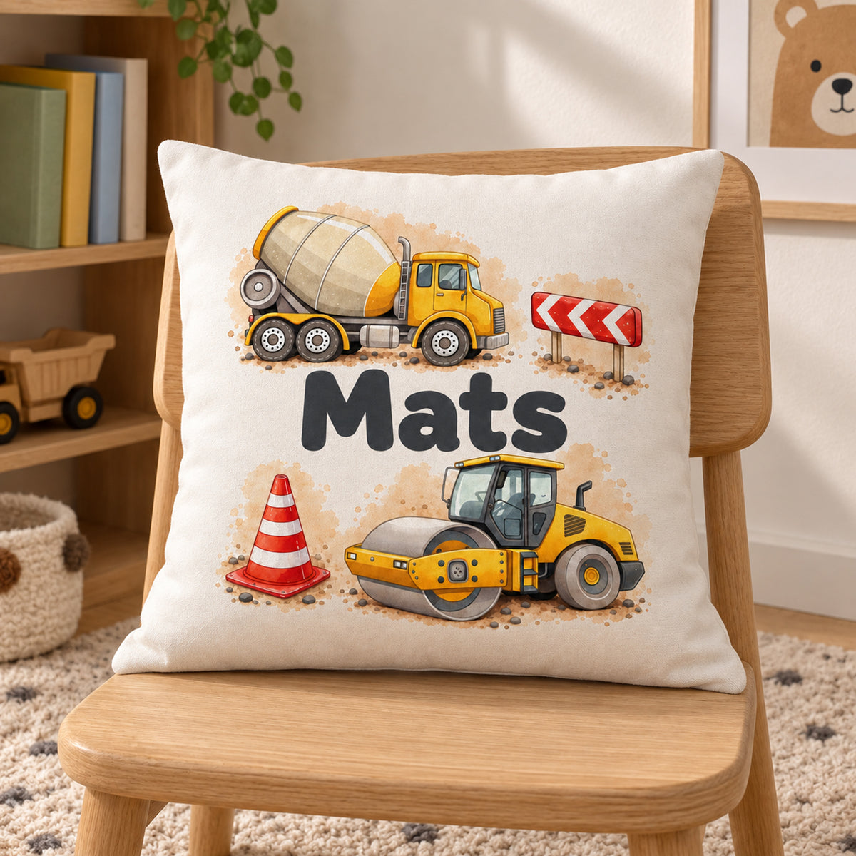 Kissenbezug mit Betonmischer und Straßenwalze und Beispielname Mats in einer Kinderzimmer-Leseecke.