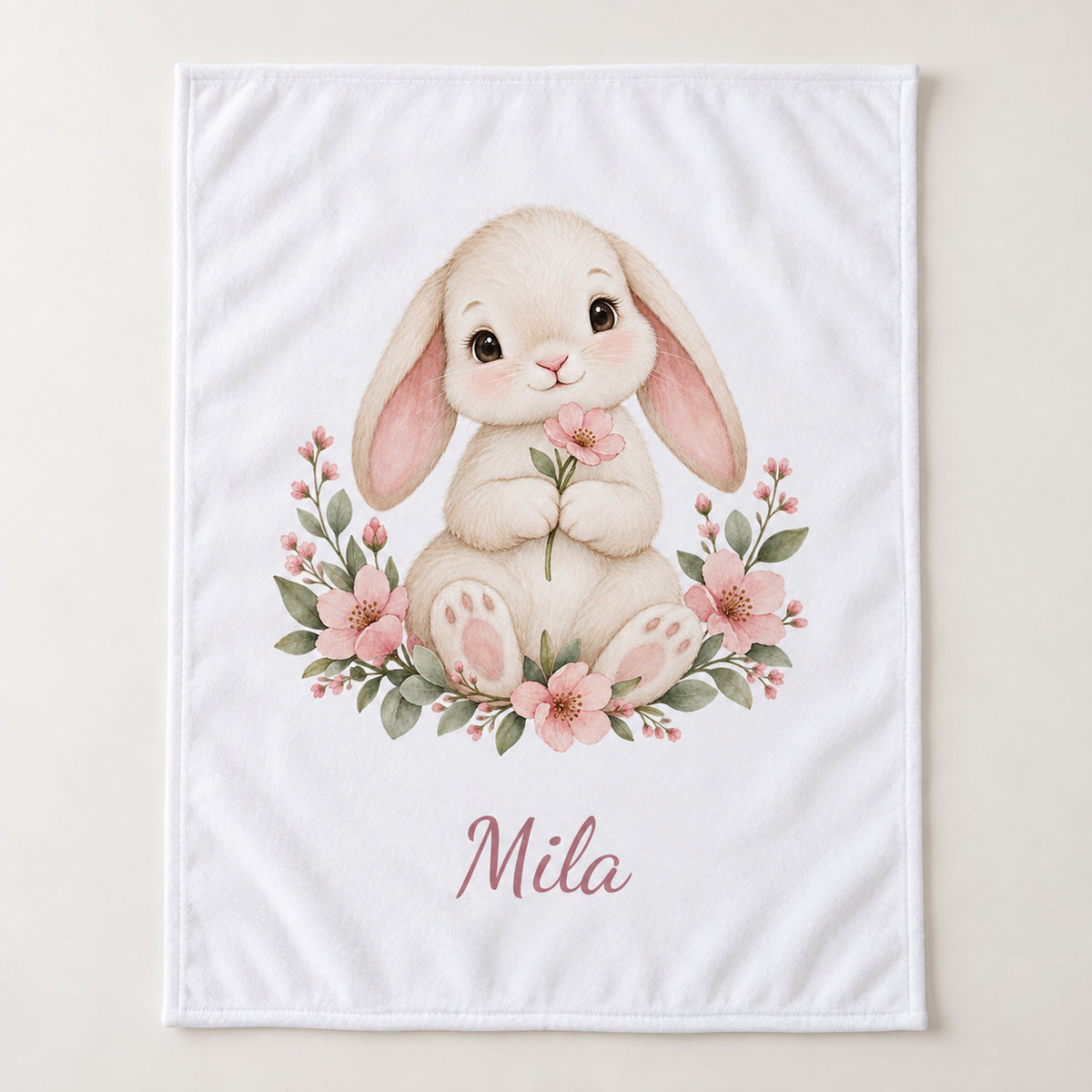 Weiße Babydecke mit Blumenhäschen und Beispielname Mila – hero