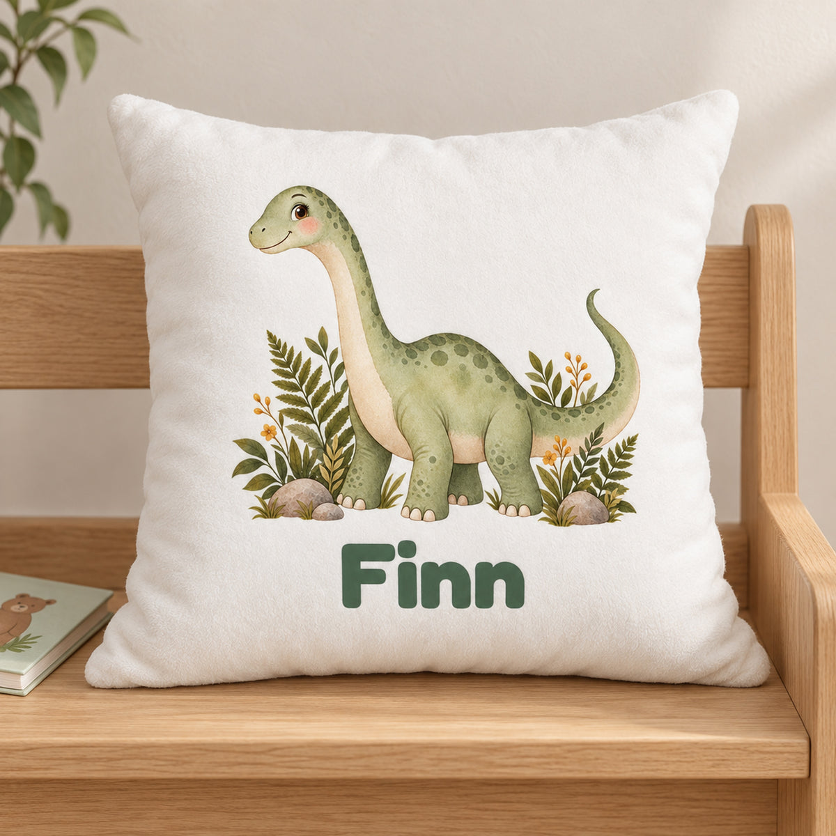 Personalisierter Dino-Kissenbezug: Langhals im Farnwald, Beispielname Finn – Gedruckte Vorderseite auf Holzstuhl