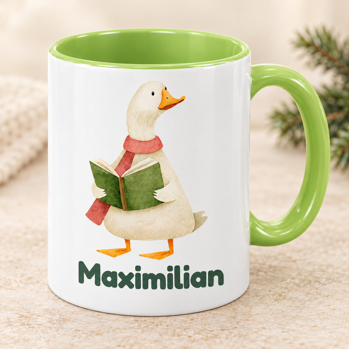 Hellgrüne Keramiktasse mit Gans mit Buch und Maximilian in einer schrägen Ansicht
