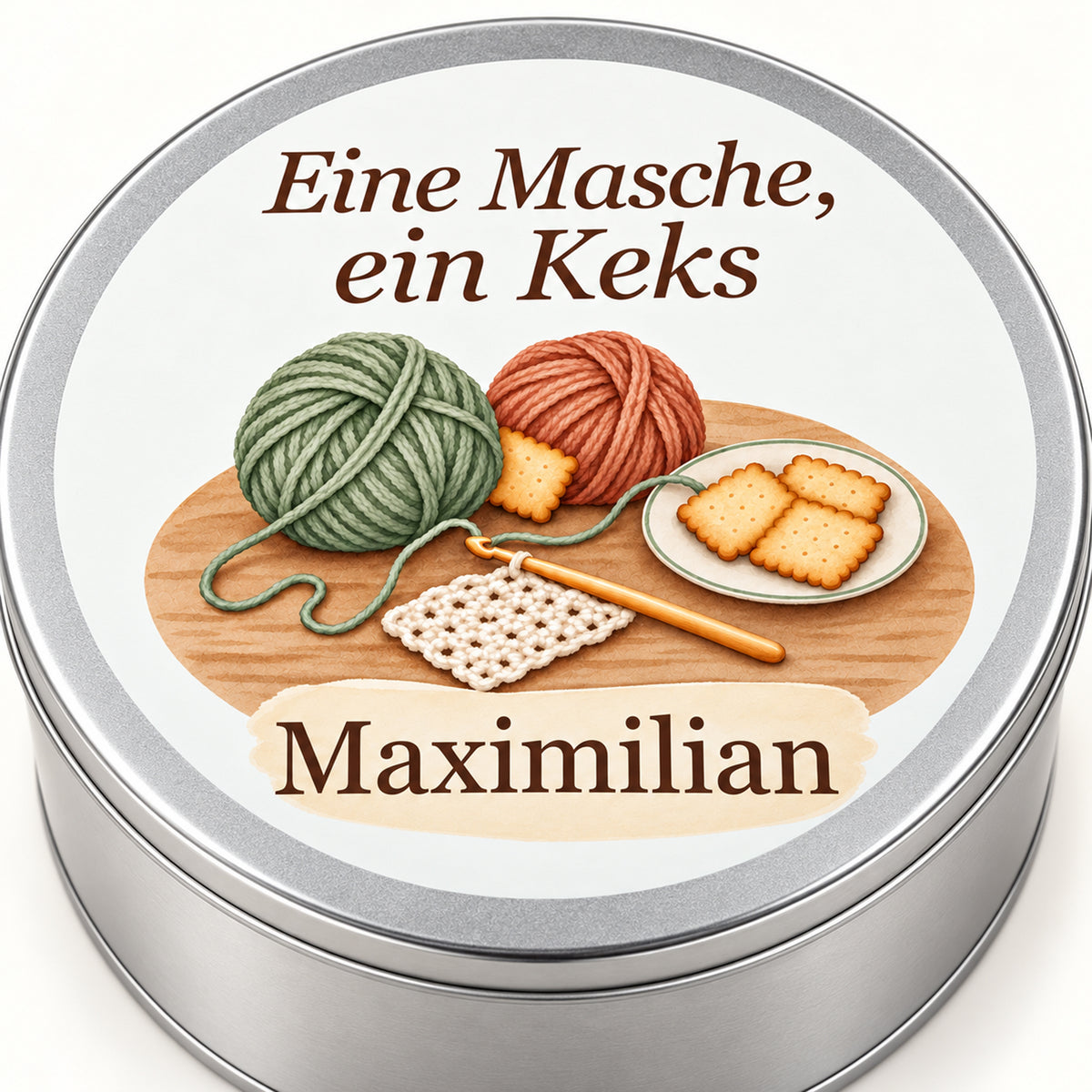 Nahansicht der Keksdose mit Wollknäueln, Häkelnadel und Keksteller, Spruch und Namensfeld.