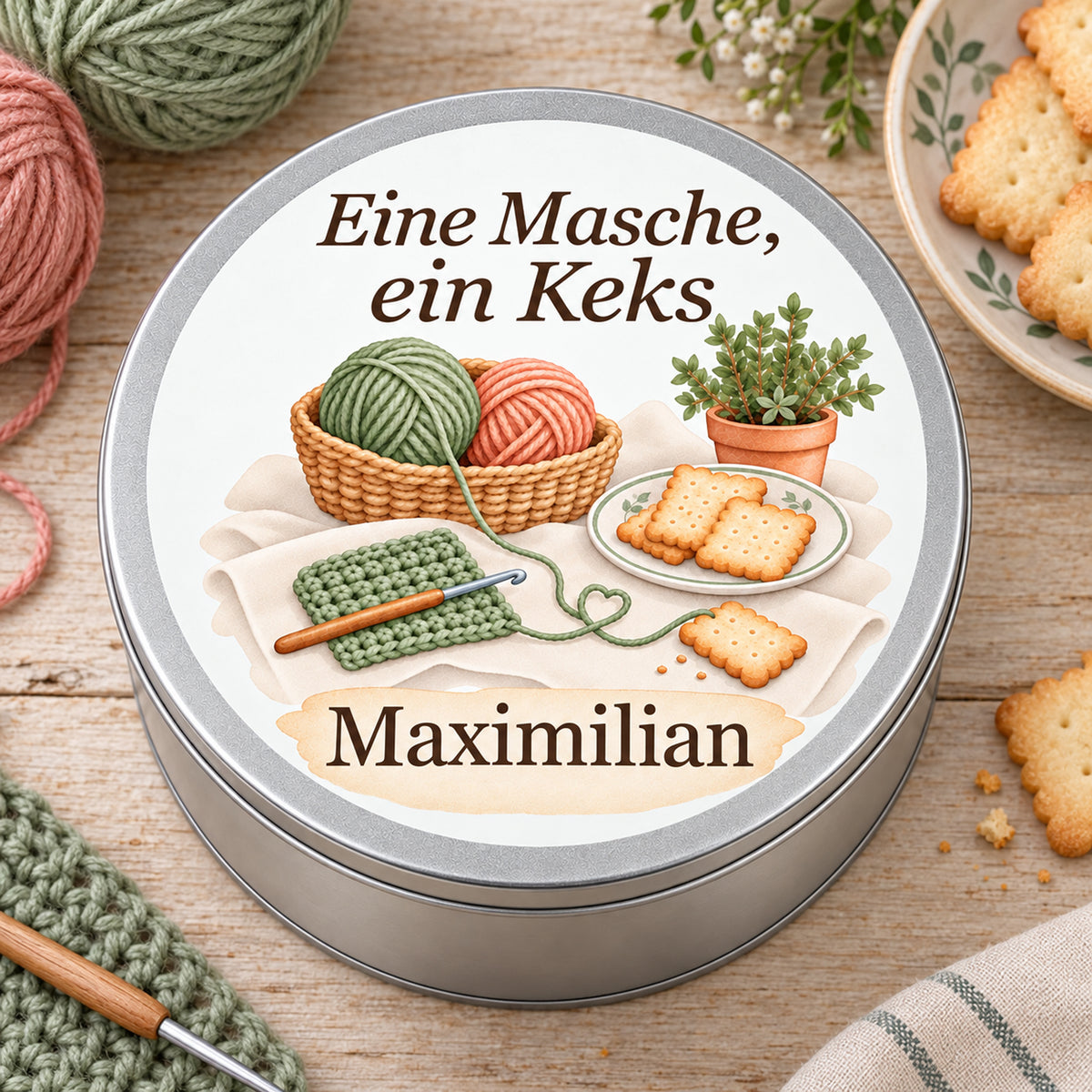 Draufsicht auf die Keksdose mit Wollkorb, Häkelstück, Keksen und Kräutertopf in einer hellen Häkelszene.
