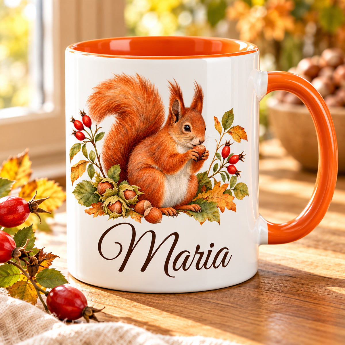 Personalisierte Eichhörnchen-Tasse mit orangefarbenem Henkel auf einem herbstlich dekorierten Holztisch.