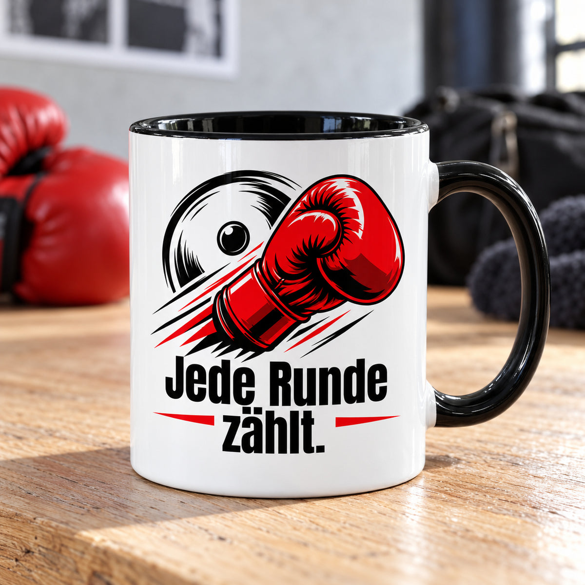 Weiße Boxsport-Tasse mit schwarzem Henkel, Rand und Innerem und Spruch „Jede Runde zählt.“ – Produktansicht in einer zum Boxsport passenden Alltagsszene.