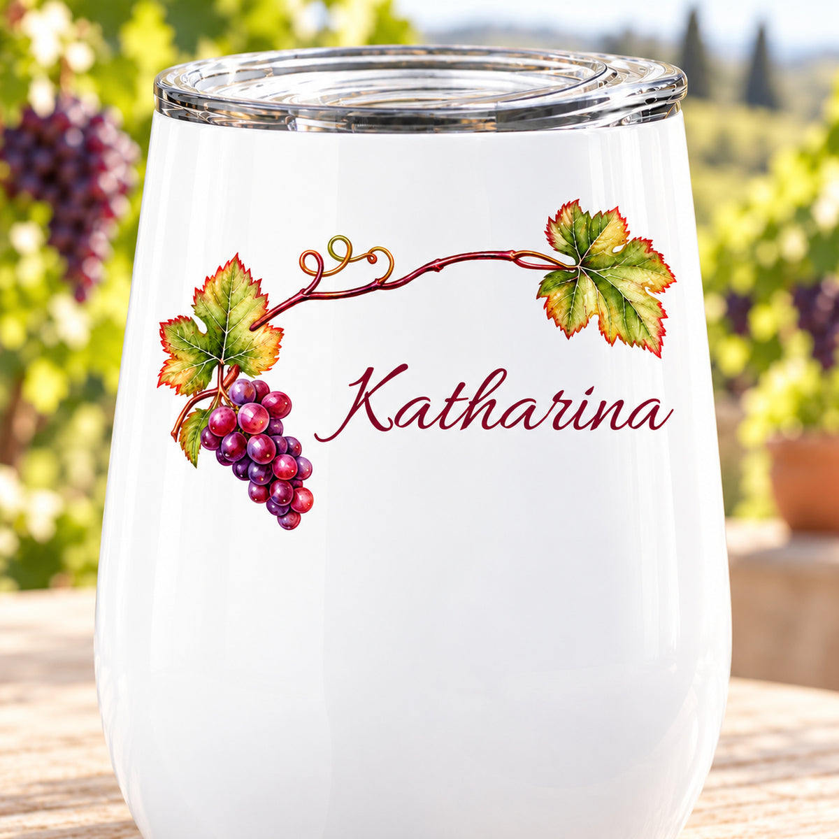 Nahaufnahme des gedruckten Motivs mit Weinlaub und Trauben und Wunschname auf weißem Weinbecher