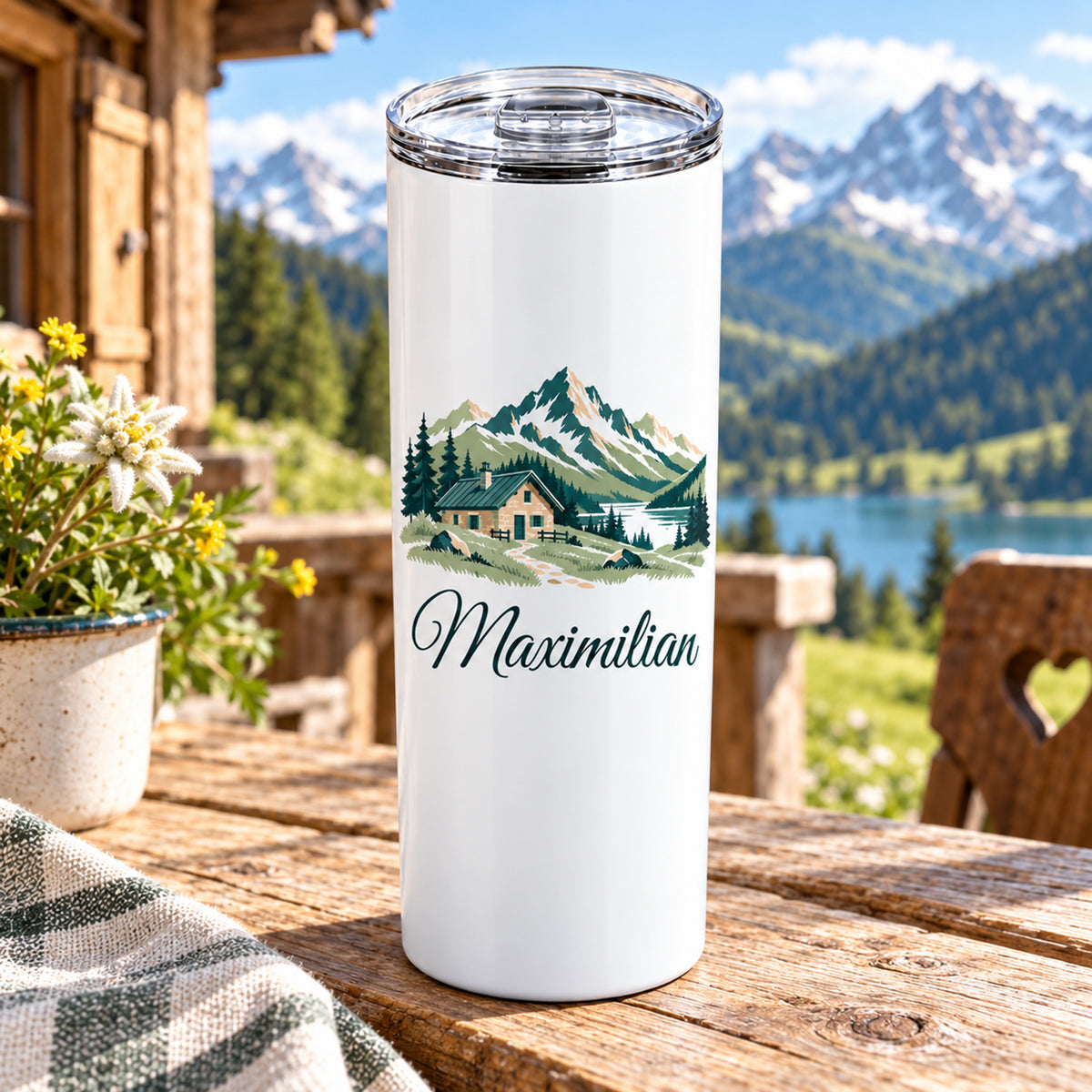 Thermobecher mit Berghütte und Bergen und Wunschname, seitlich auf einem Tisch dargestellt.