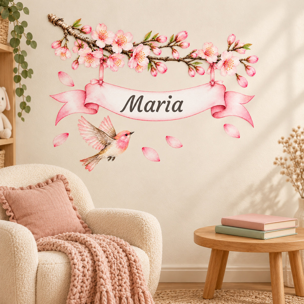 Personalisiertes Kirschblüten-Wandtattoo mit Vogel und rosa Namensband-Enden über einer gemütlichen Leseecke.