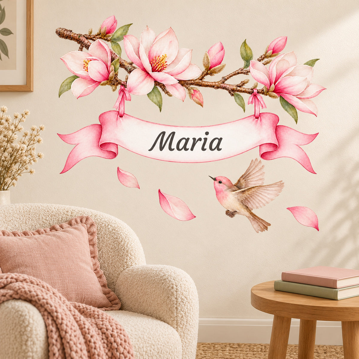 Personalisiertes Magnolien-Wandtattoo mit Vogel und rosa Namensband-Enden über einer gemütlichen Leseecke.