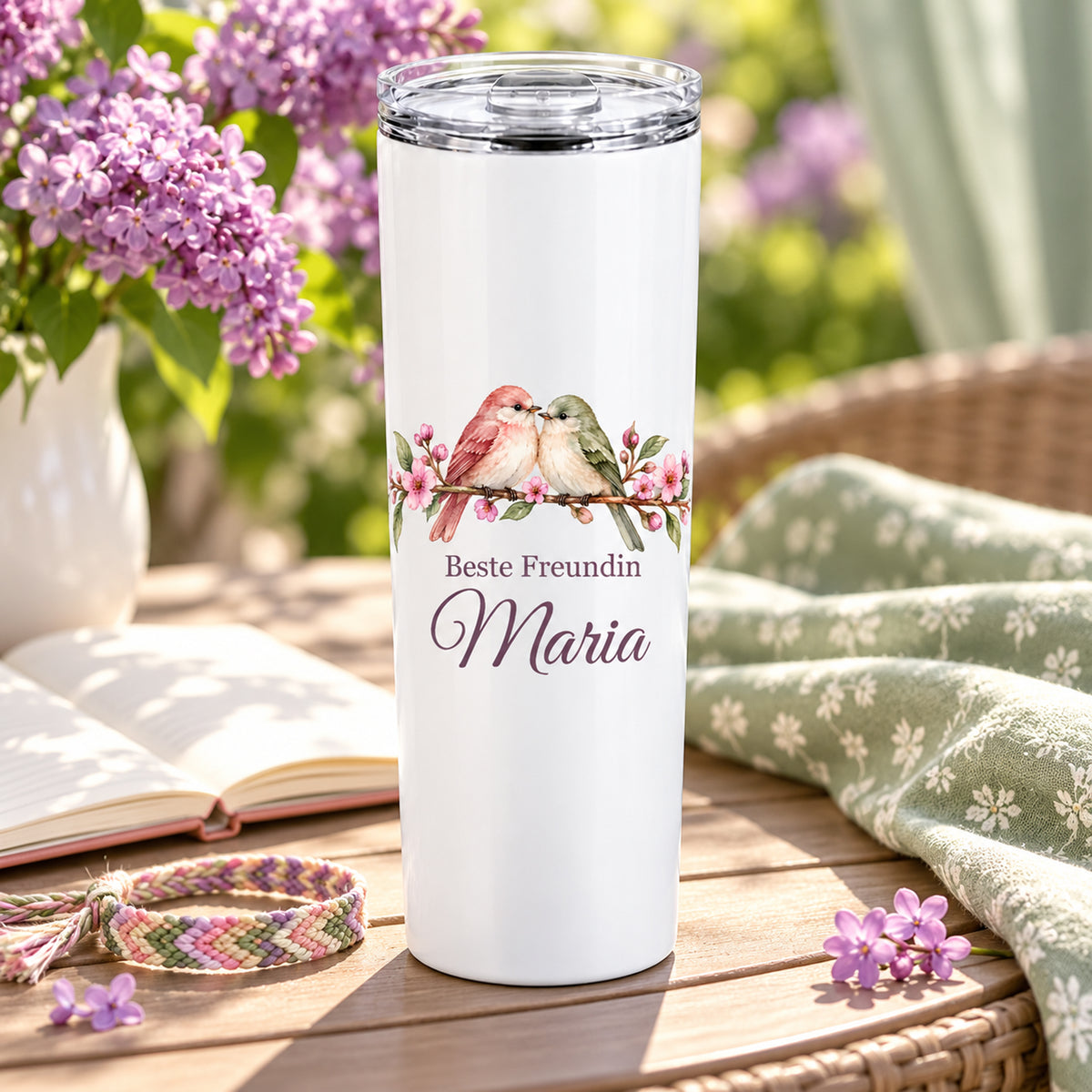 Weißer Thermobecher mit Motiv Freundschaftsvögel, Schriftzug Beste Freundin und Wunschname in einer wohnlichen Umgebung.