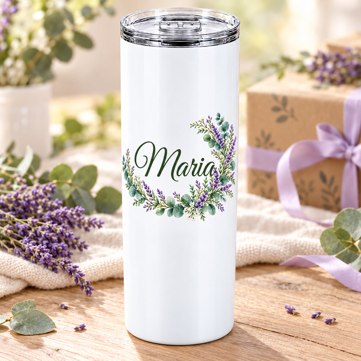 Weißer Thermobecher mit Motiv Lavendelzauber, Blumenranke und Name Wunschname auf einem dekorierten Geschenktisch.