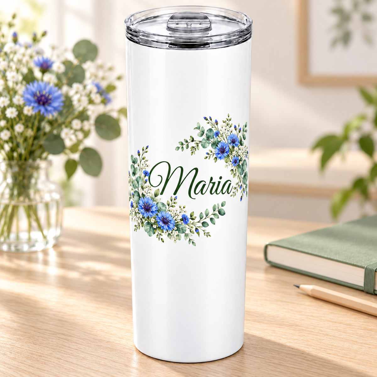Weißer Thermobecher mit Motiv Kornblumentraum, Blumenranke und Name Wunschname in einer wohnlichen Umgebung.