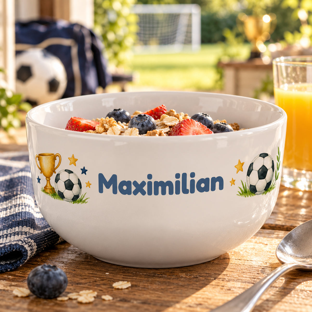 Müslischale mit Siegerpokal und Fußball und Wunschname auf einem gedeckten Frühstückstisch