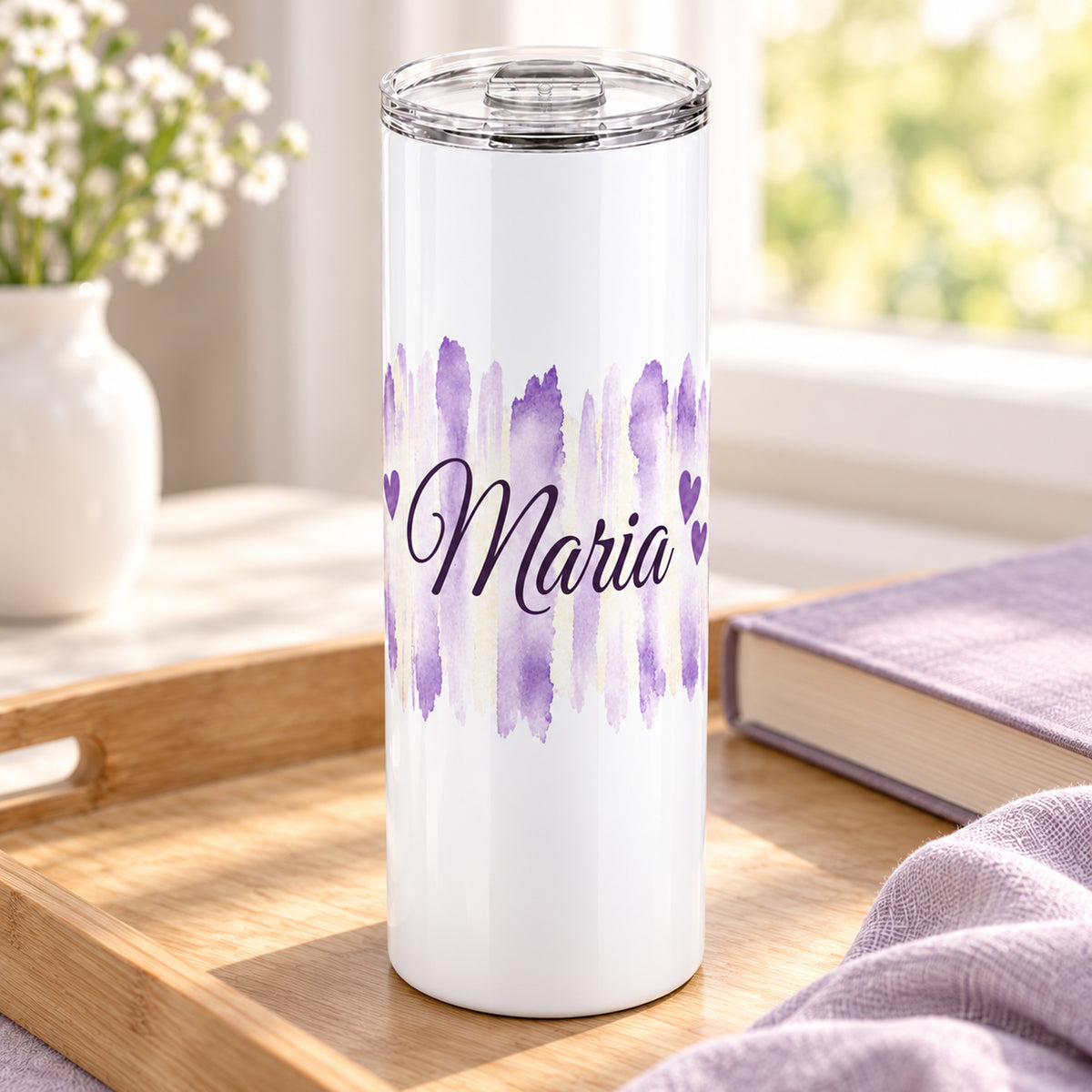 Weißer Thermobecher mit Motiv Fliederliebe, personalisiertem Namen in einer wohnlichen Umgebung.