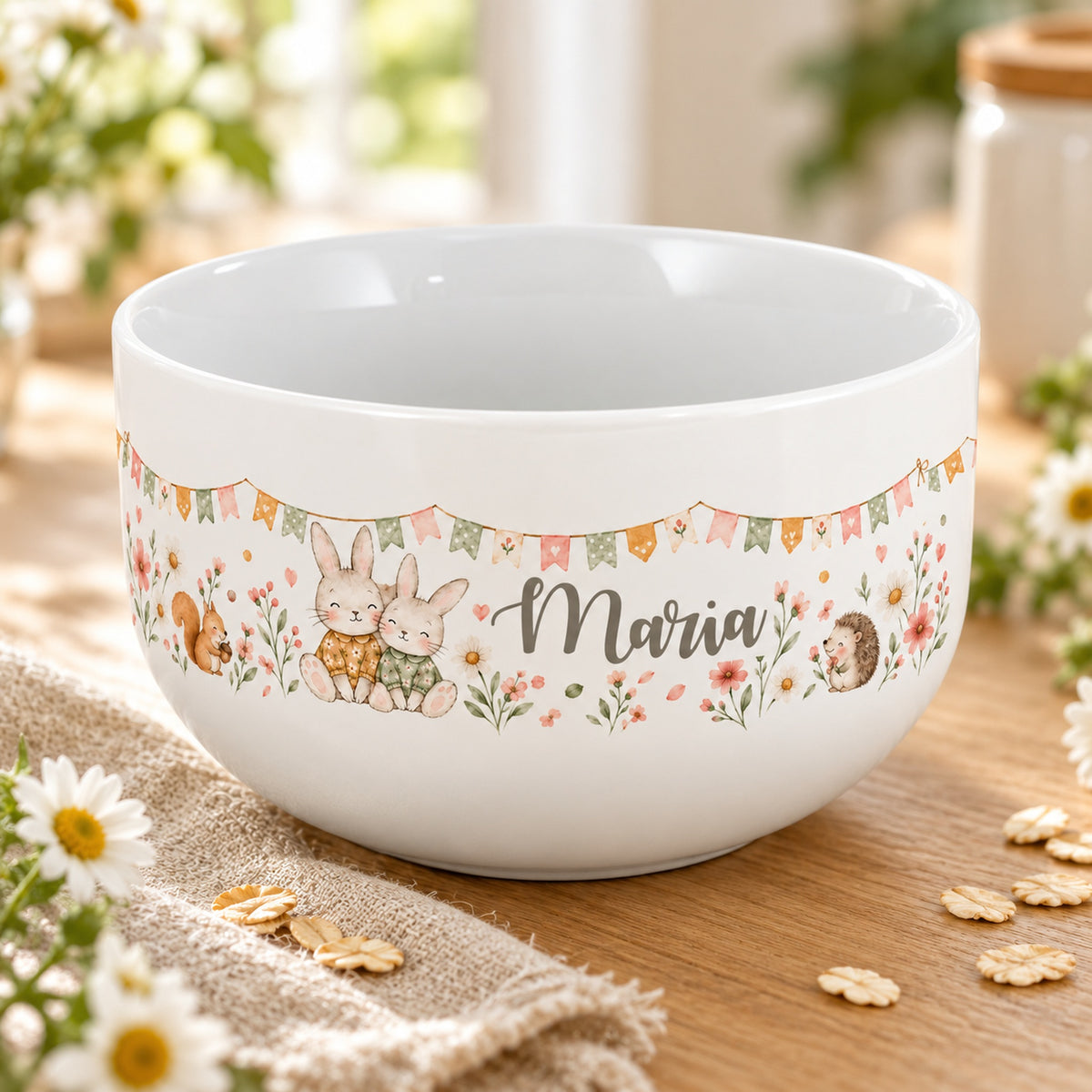 Personalisierte Keramik-Müslischale mit zwei kuschelnden Häschen, Eichhörnchen und Igel und Blumen auf einem hellen Tisch.