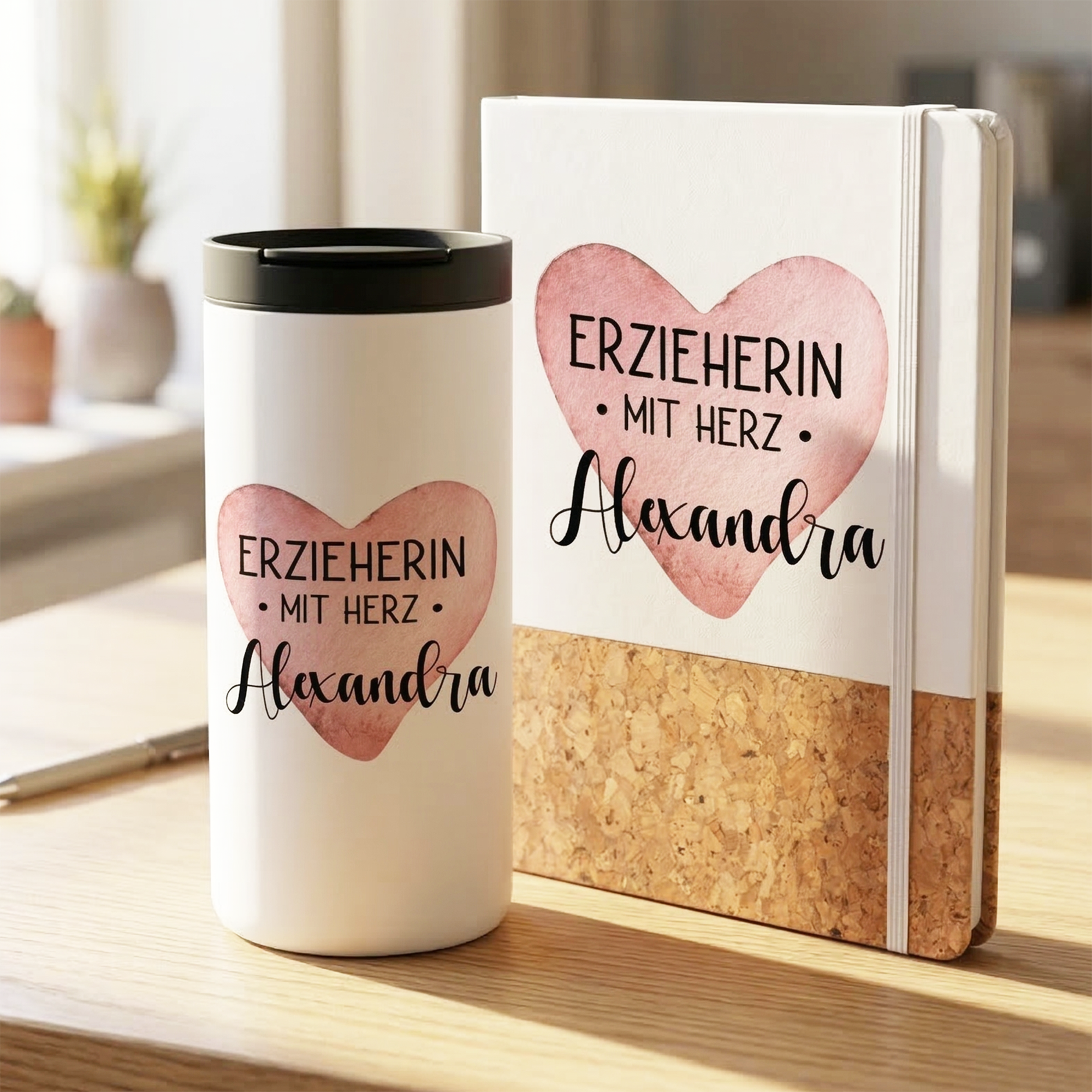Thermobecher und Notizbuch mit Herzmotiv, weiß und rosa.