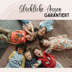 Sechs fröhliche Kinder auf einem Teppich, bunte Kleidung.