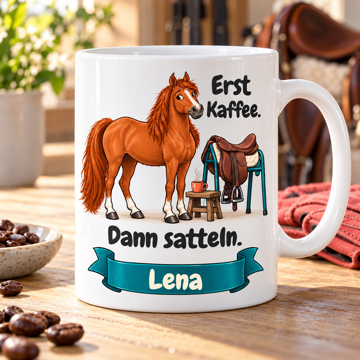 Weiße Pferdetasse mit Namen, Fuchs neben Sattel und Kaffeetasse und Spruch „Erst Kaffee. Dann satteln.“, auf heller Ablage.
