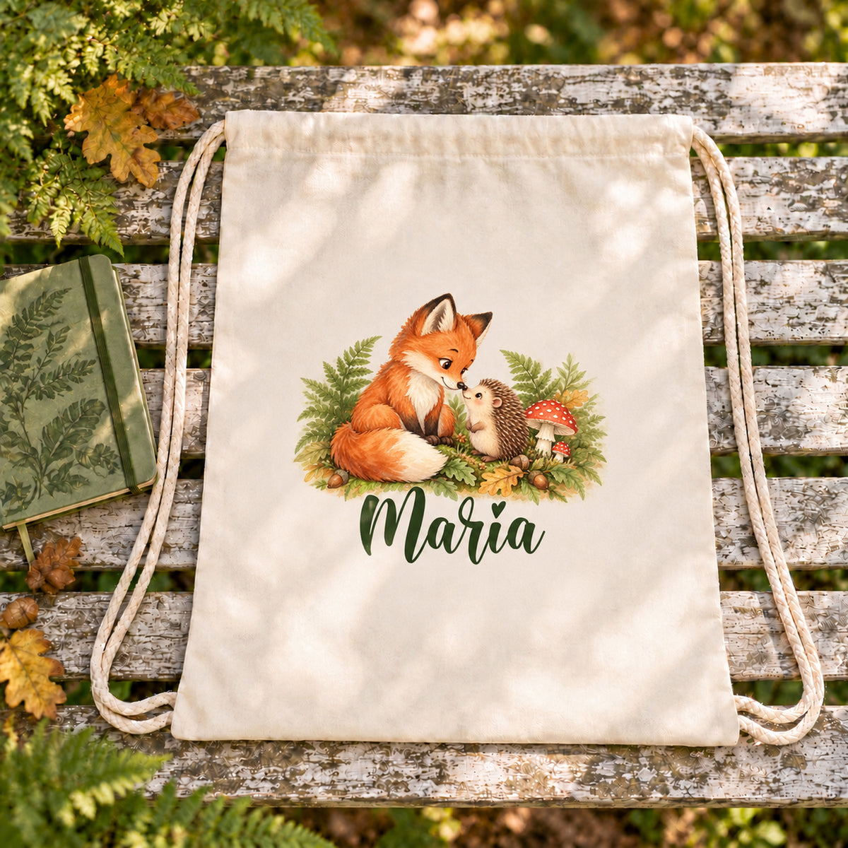 Personalisierter Turnbeutel mit Fuchs und Igel auf einer Gartenbank zwischen grünen Pflanzen