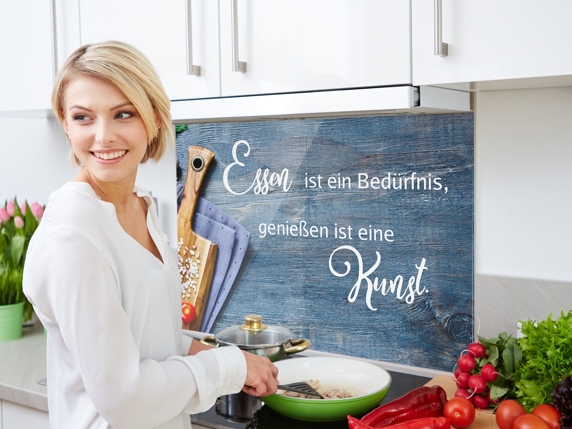 Frau kocht mit frischem Gemüse in moderner Küche.