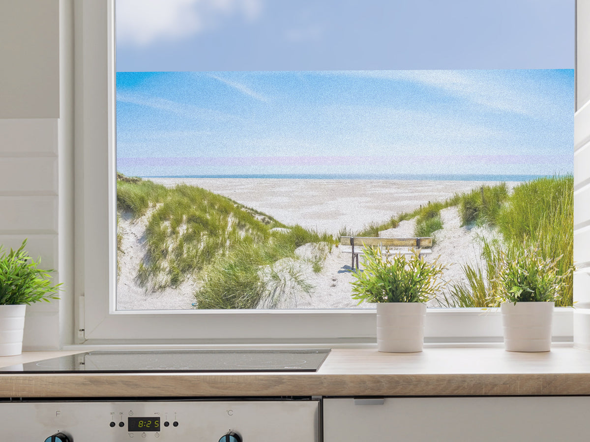 Küchenfenster mit Blick auf Sandstrand und Dünen.