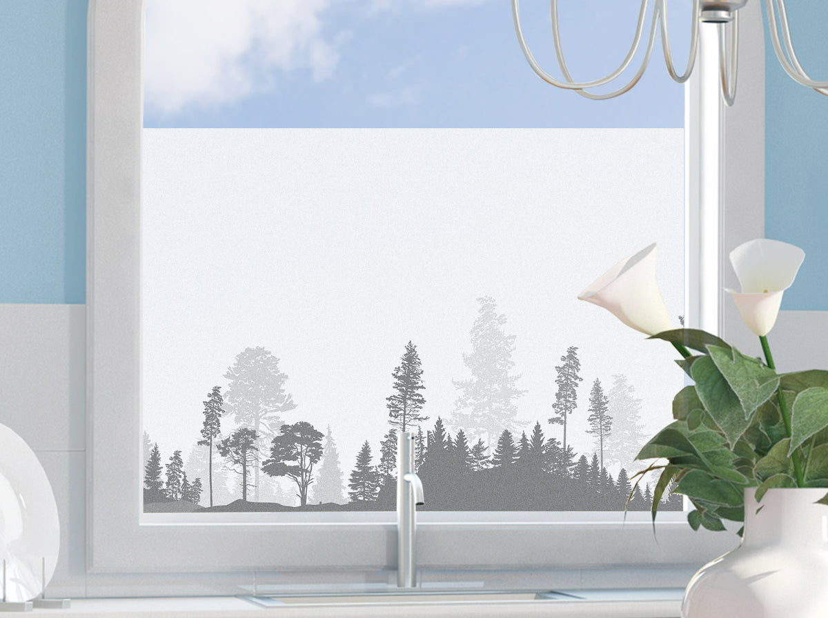 Fensterfolie mit grauem Waldmotiv und klarem Himmel.