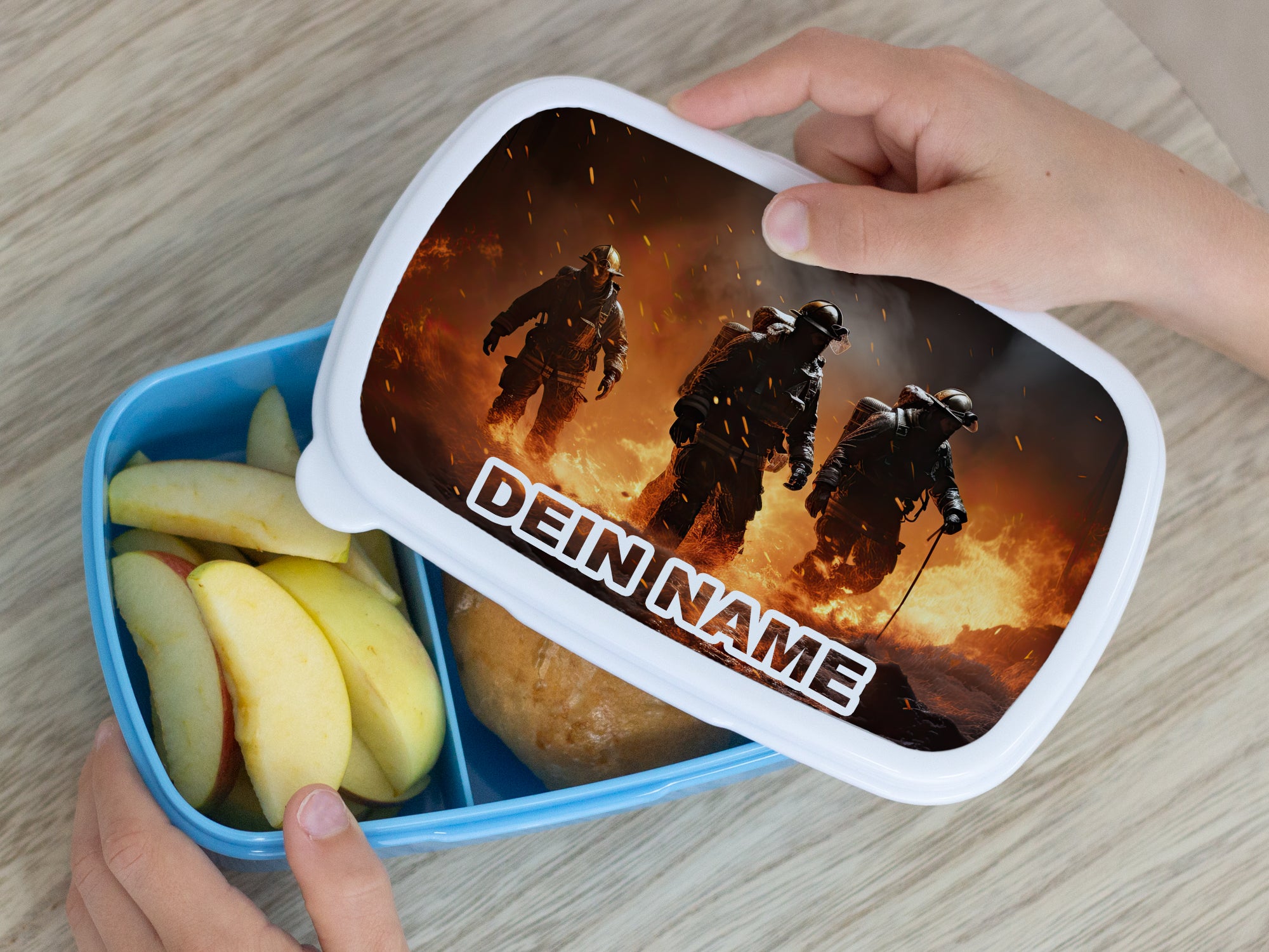 Blaue Brotdose mit personalisiertem Deckel und Apfelstücken.